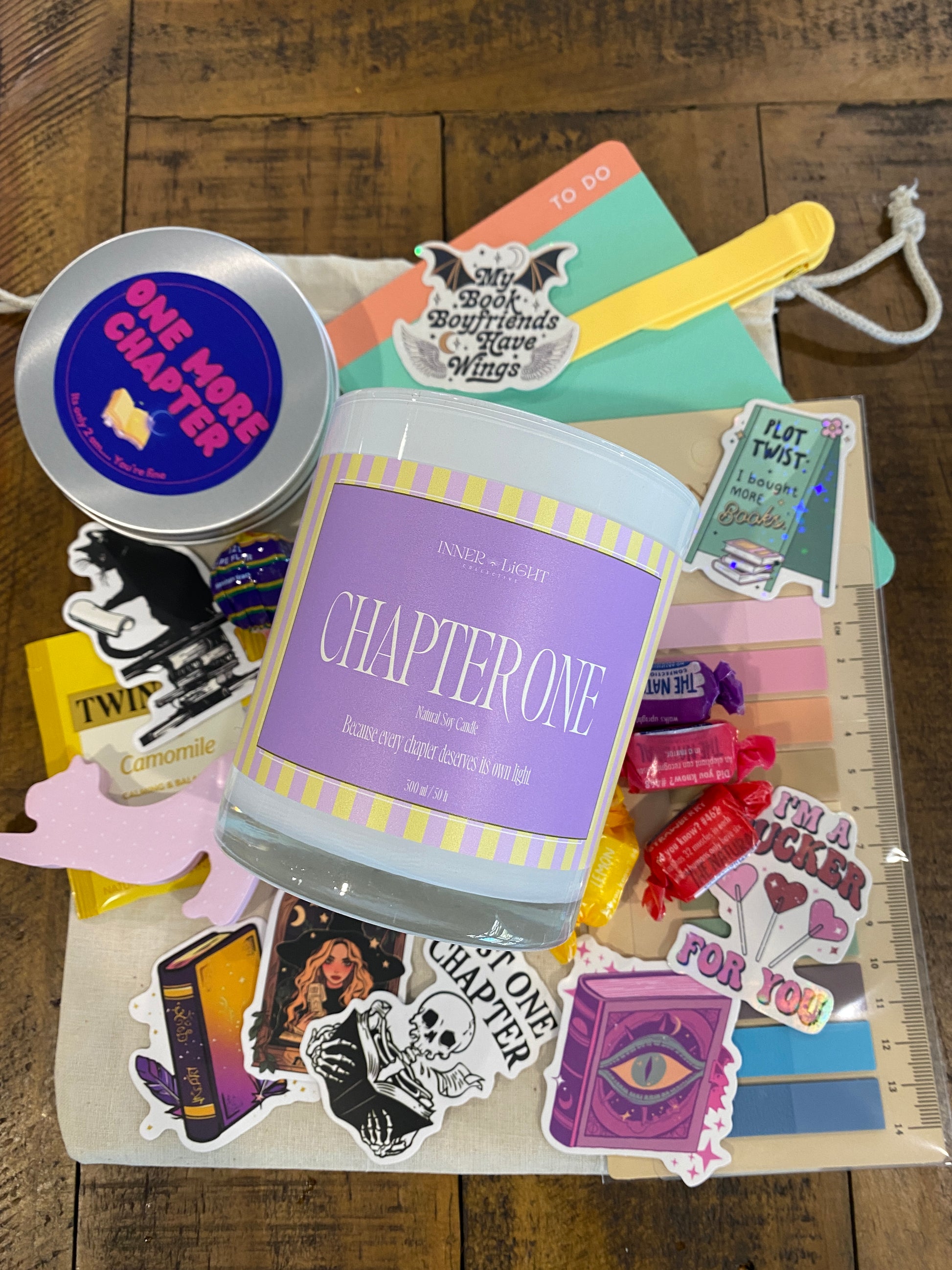 Collection of books, stickers, and a container labeled 'Chapter One' on a wooden surface.