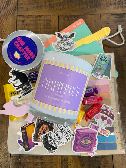 Collection of books, stickers, and a container labeled 'Chapter One' on a wooden surface.